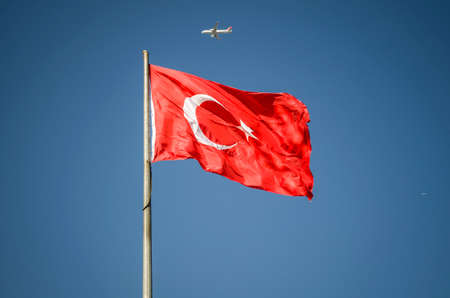 turkish flag waving and airplane in blue sky istanbul turkeyの写真素材