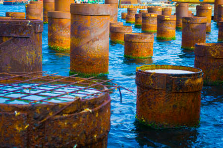 Rusty steel pillars of old pier in the foreground