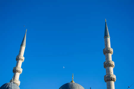 New mosque's minaret with crescent moon in the blue sky istanbul turkeyの写真素材