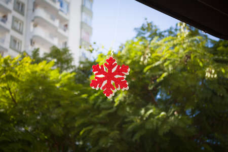 foam plastic like red snow on green tree blur background