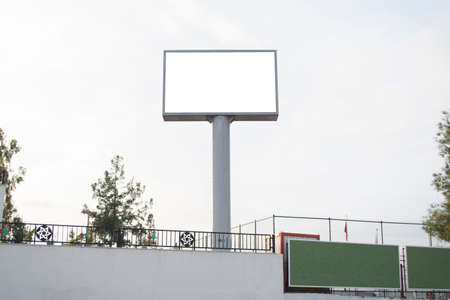 horizontal blank billboard on the city street in background could sky and road with wall mock upの写真素材