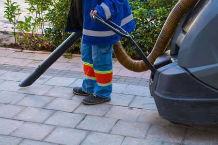 Street cleaner walking in central city with industrialの写真素材