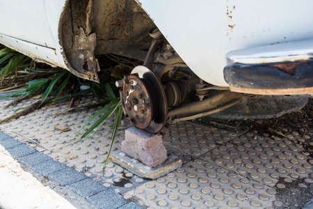 Old car waiting for the wheel. Car without tire need to be repaired.