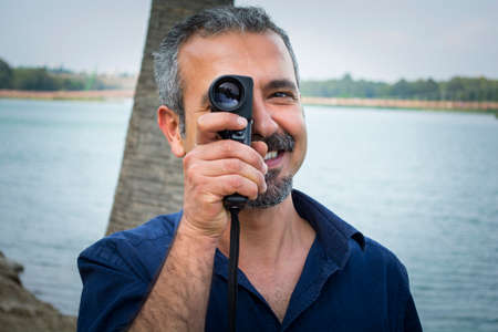 Man with old vintage camera in hands.