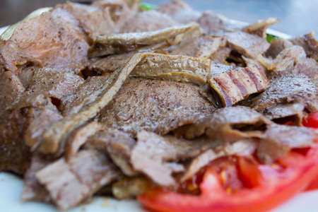 turkish iskender kebab with garnish on a wooden surface at restaurantの写真素材