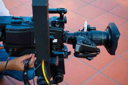 Cameraman checking equipment of camera in broadcast television green screen virtual studio room.