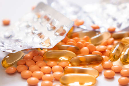 Heap of various pills and thermometer on white background.の写真素材