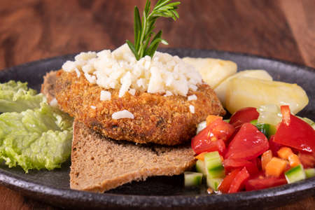 Vegan baked sweet potato meatballs, guacamole and vegetables salad. Wooden background, healthy...