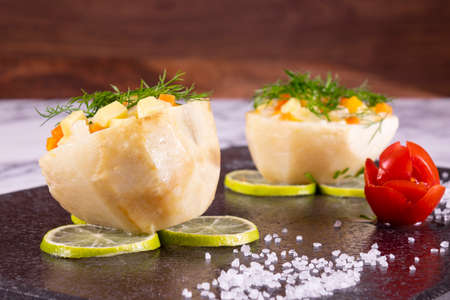 Artichoke food meal staffed with carrot and potatoes. This arthichoke dish on black marble plate....