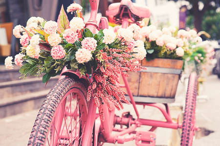 Rusty tricycle bike with flower pot in tray against blured background.の写真素材