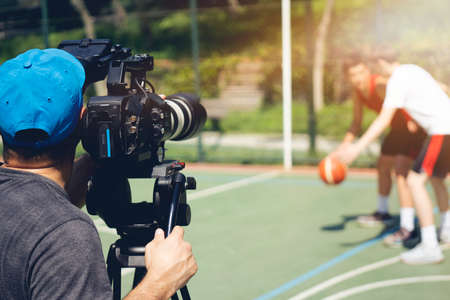 Blurry image of movie shooting or video production and film crew team with camera equipment at outdoor location and light flare effect.の写真素材