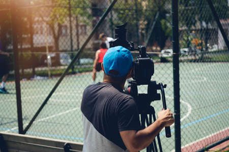 Blurry image of movie shooting or video production and film crew team with camera equipment at...