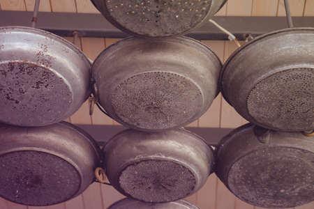 Metal sieve nailed to the wallの写真素材