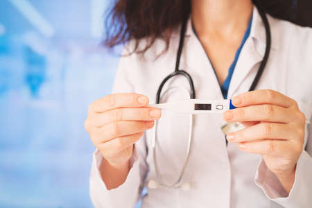 Young doctor woman holding thermometerの写真素材
