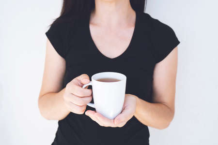 Close up of design with tea or coffee or heahty drink holded by adult caucasian woman hands