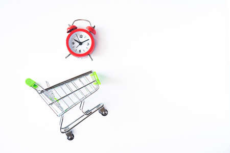 Buying time concept with clock and shopping cart