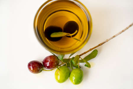 Olive oil and black olive branch isolated on white backgroundの写真素材