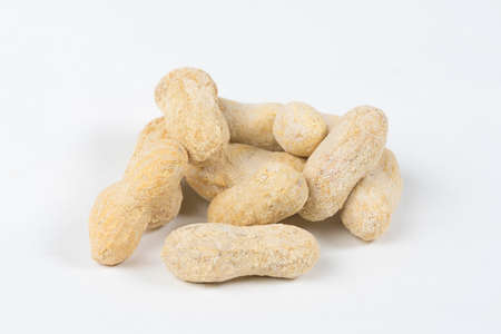Shelled salted peanuts in shell on white background
