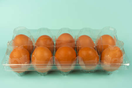 Eggs in a plastic package with isolated turquoise background.