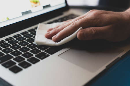 Covid-19 sanitizing office space wiping corona virus cleaning and disinfection of your workspace. Disinfecting wipes to wipe surface of desk, keyboard, mouse at office. Stop the spread of coronavirus.の写真素材