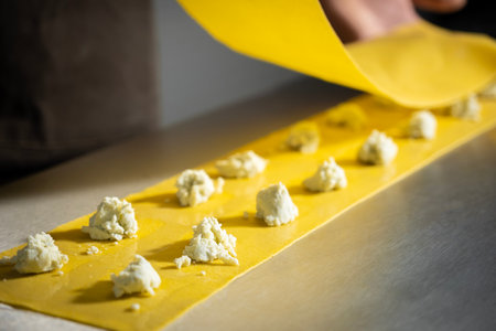 Preparing fresh made ravioli with ricotta cheese inside pasta factory. Making four cheese ravioli.の写真素材