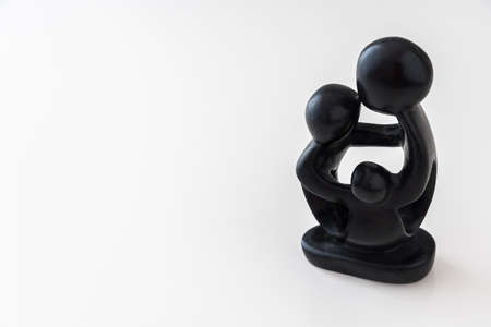 African black wooden figure of a family hugging each other. Isolated on white background with copy...
