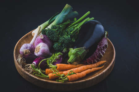 Variety of vegetables on a wooden tray, vegeterian food conceptの写真素材
