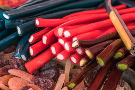 Red, brown and black licorice canes on a market standの写真素材