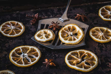 Three lemons and oranges slices on an old baking sheet. Used for christmas decoration.の写真素材