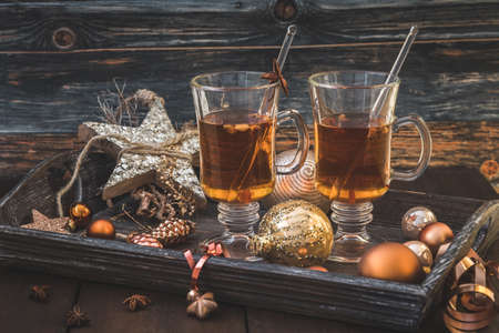 Two glasses with tea on a Christmas decorated wooden trayの写真素材