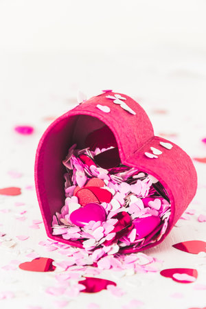 Little red, pink and white hearts for decoration pour out of a heart-shaped little box. Vertical with copy space.の写真素材