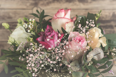 Flower bouquet with pink and white roses on wooden background, vintage styleの写真素材