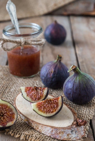 Fig jam in a jar on a rustic wooden table, vertical stock photoの写真素材