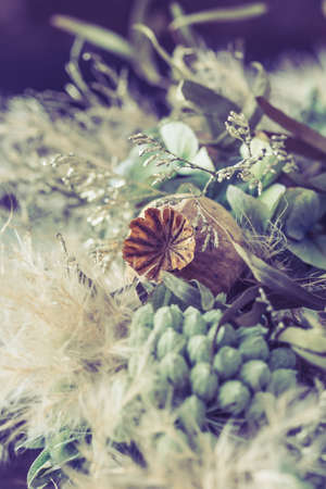 Close-up of a wreath of dried flowers in light green and white winter colors, vintage style, verticalの写真素材
