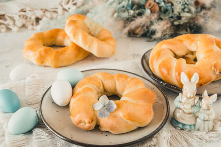 Homemade easter buns on a table decorated for easter brunch or breakfastの写真素材