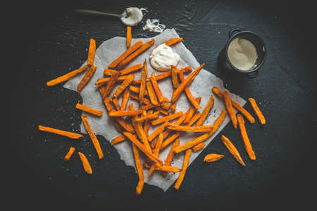 Sweet potato fries with sour cream dip on black background, top viewの写真素材