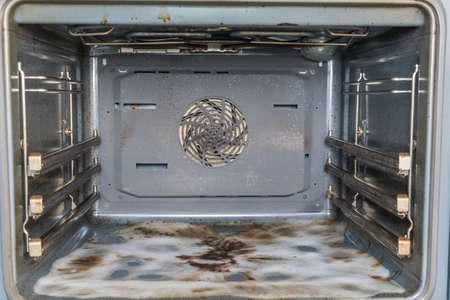 Dirty open oven, bottom covered with cleaning foamの写真素材
