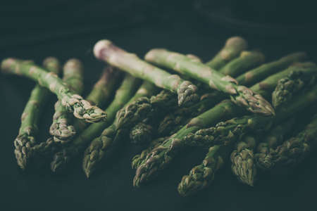 Fresh raw green asparagus on dark background, copy spaceの写真素材