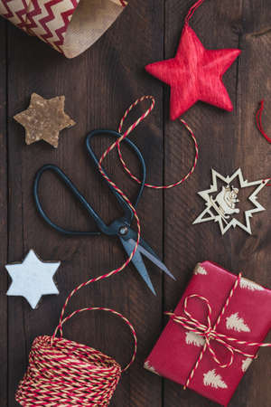 Top view on christmas gift scene with present, ribbon, paper, cookies and decorationの写真素材