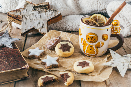 Cup with mulled wine or punch or spiced tea with christmas cookies, harmonious light colors, christmas coffee breakの写真素材