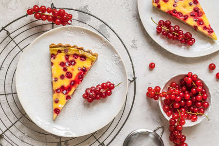 Pieces of homemade red currant pie on white background, decorated with fresh red currants, top viewの写真素材