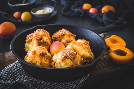 Sweet dumplings with sweet breadcrumbs, filled with apricots, on black backgroundの写真素材