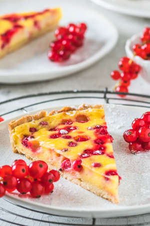 Piece of homemade red currant pie on white background, verticalの写真素材