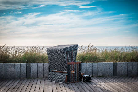 Precious brown wicker beach chair on promenade in Wenningstedt, Sylt, Germanyの写真素材