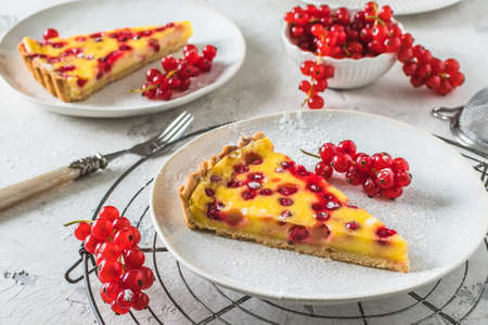 Piece of homemade red currant pie on white background, decorated with fresh red currantsの写真素材