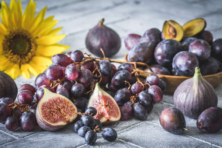 Fruit harvest in autumn: figs, grapes and plums