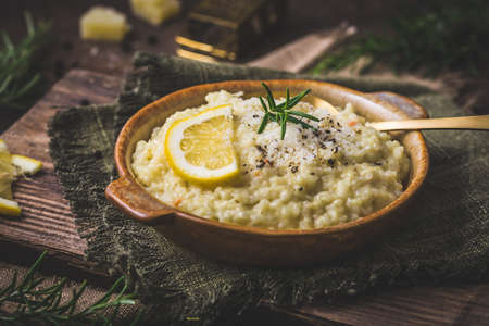 Lemon rice risotto with rosemary on dark wooden backgroundの写真素材