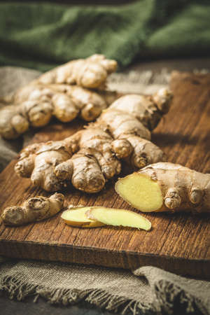 Fresh ginger on a wooden board, verticalの写真素材