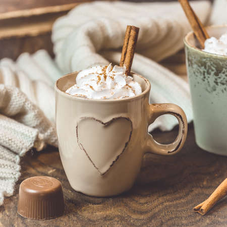 Cup of coffee or hot chocolate with cream and cinnamon on wooden background, squareの写真素材