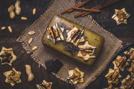 Star shaped cookies, an old vintage metal can, peanuts and chocolate, top view. Christmas or baking scene.の写真素材